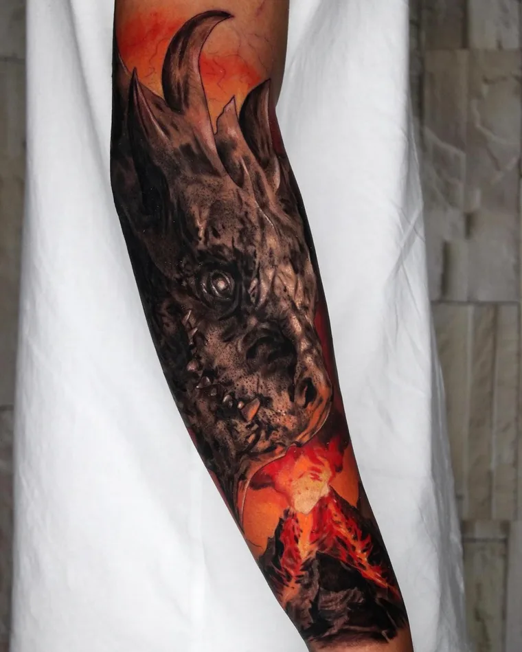Farbiges Drachen-Tattoo mit Vulkan auf dem Unterarm