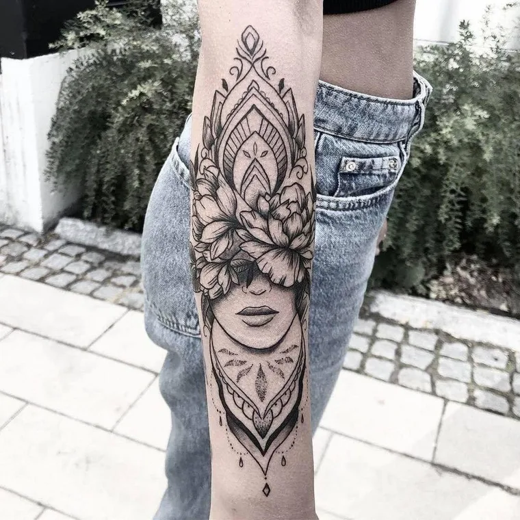 Ornamentales Fineline-Tattoo mit Frauengesicht und Blüten auf dem Unterarm