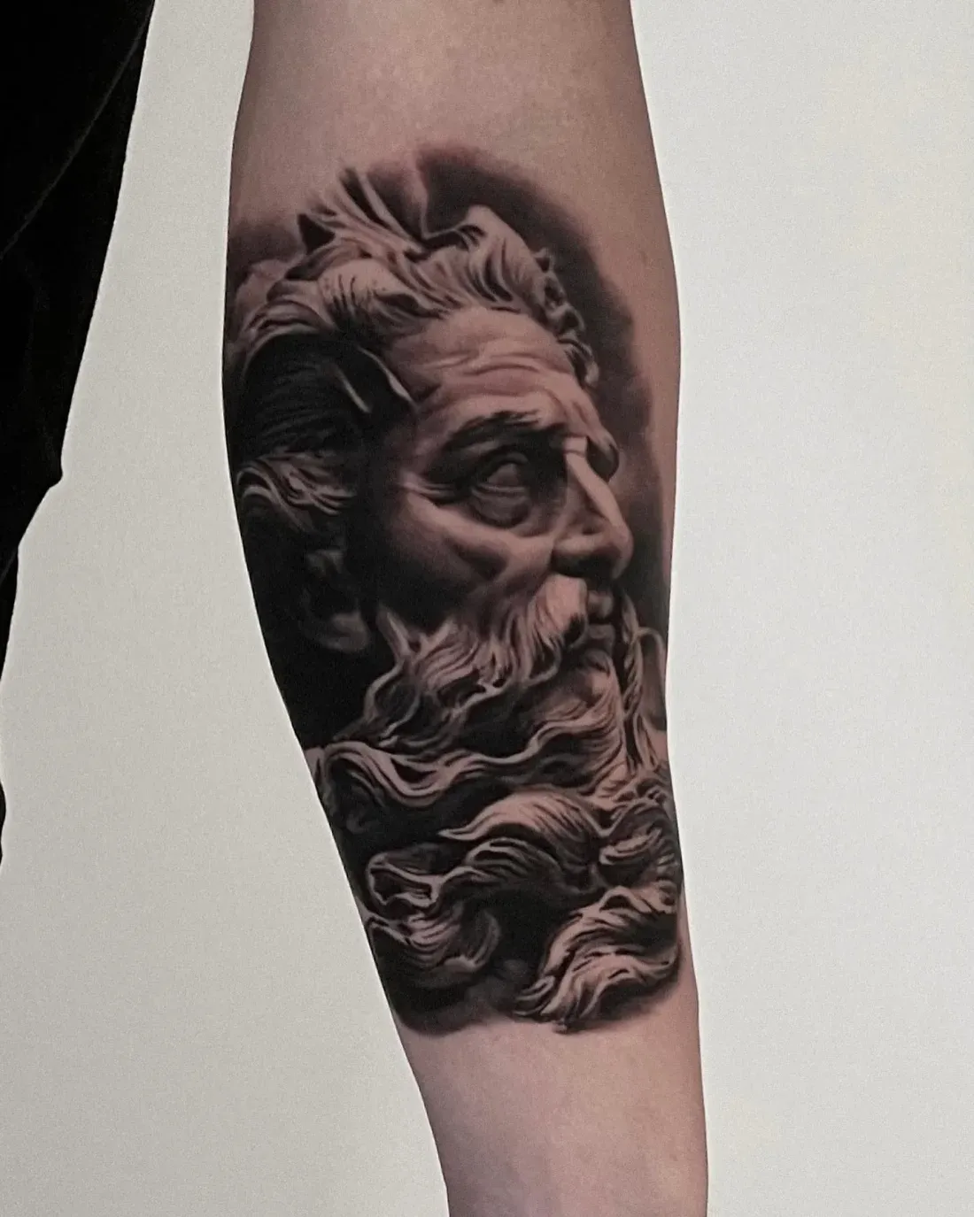 Poseidon-Statuenkopf als realistisches Tattoo — LAKIMII Berlin