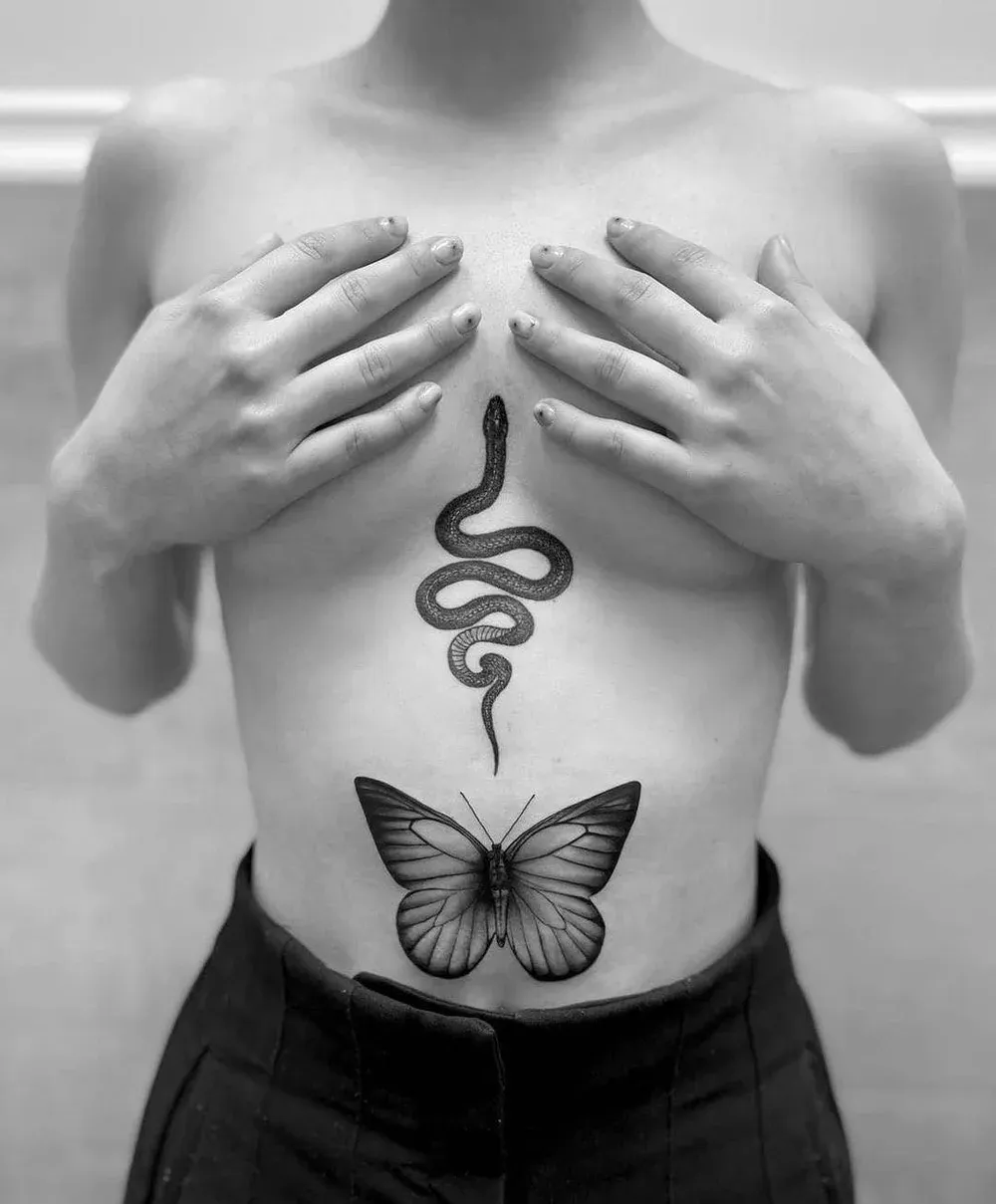 Tattoo mit Schlange und Schmetterling auf dem Bauch — eine der schmerzempfindlicheren Körperstellen