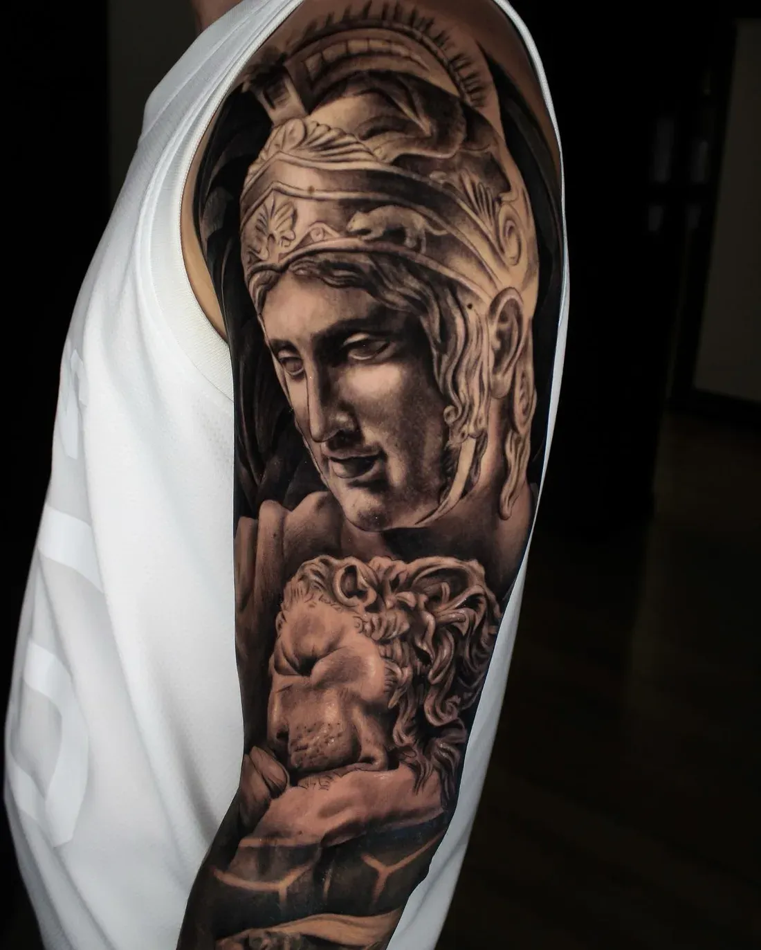 Realistisches Statuen-Tattoo mit Löwe auf dem Oberarm aus dem LAKIMII Tattoostudio im Bezirk Pankow